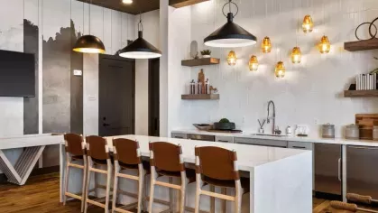 A sleek business center with wooden accents, private workstations, and high-speed internet access.