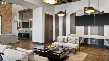 A cozy community lounge with modern furnishings, warm lighting, and a stylish seating area.