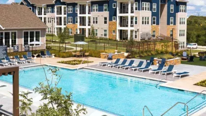 A spacious outdoor fitness area with high ceilings, functional training equipment, and natural lighting.