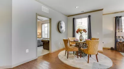 A stylish dining space with elegant seating, a round dining table, and large windows allowing natural light to enhance the ambiance.