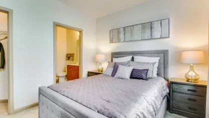 A sophisticated bedroom with a tufted headboard, soft bedding, and warm lighting, offering a comfortable and stylish retreat.