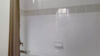 A well-lit bathroom with a combination bathtub and shower, complemented by a neutral color palette and sleek finishes.