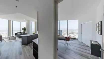 Hallway view in Nari Koreatown penthouse looking into the living room and home office, with abundant natural light and skyline vistas