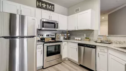 Modern kitchen with stainless steel appliances, granite countertops, and white cabinetry at Gates at Citiplace apartments in Baton Rouge, LA