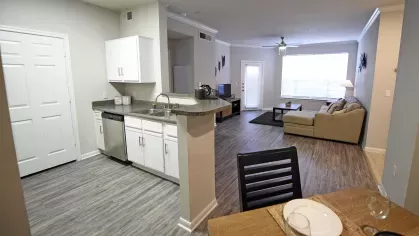 Open-concept kitchen and spacious living room with wood-style floors at Gates at Citiplace apartments