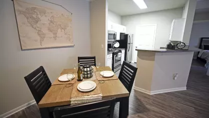 Compact dining nook adjacent to modern kitchen with stainless steel appliances at Gates at Citiplace