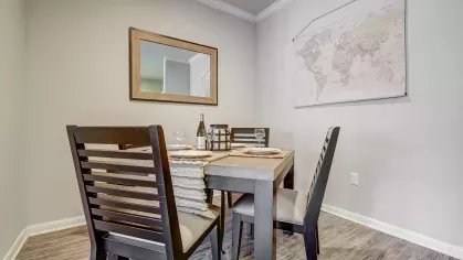 Elegant dining area with wood-look flooring and world map wall art at Gates at Citiplace in Baton Rouge
