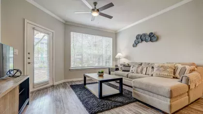 Comfortable living room with modern furnishings and large window at Gates at Citiplace apartments