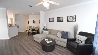 Spacious living room at Gates at Citiplace apartments in Baton Rouge featuring modern flooring, crown molding, and open-concept dining.