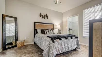 Modern bedroom at Gates at Citiplace featuring natural light, contemporary ceiling fan, and vinyl plank flooring.