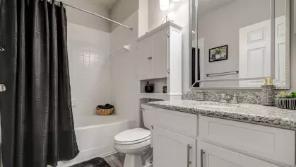 Luxury bathroom with granite countertops and framed mirror at Gates at Citiplace apartments in Baton Rouge