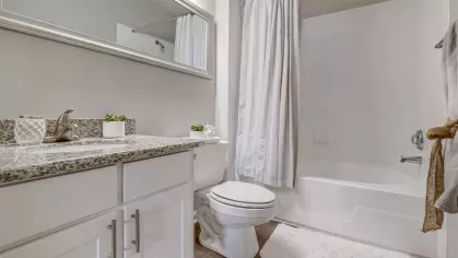 Bright, clean bathroom with granite vanity and full-size tub at Gates at Citiplace apartments in Baton Rouge, LA.