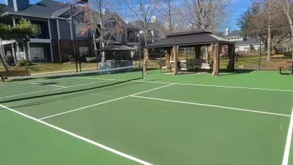 Outdoor tennis and pickleball court with shaded seating pavilion at Gates at Citiplace community