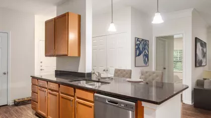Virtually staged open kitchen with granite countertops, stainless steel appliances, and a view into the living and dining area at Grandview at Lake Murray.