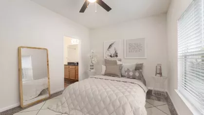 Virtually staged bedroom at Grandview at Lake Murray with a plush bed, ceiling fan, large mirror, and modern neutral decor.