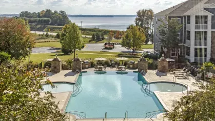 Aerial view of the community pool with stone accents and Lake Murray visible beyond the landscaped grounds