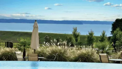 Scenic view of Lake Murray from the poolside seating area with patio umbrellas and ornamental grasses
