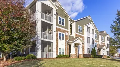 Side view of apartment buildings with balconies and landscaped lawn