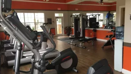 On-site fitness center at Knob Creek Apartments equipped with treadmills, weight machines, and mirrored walls.