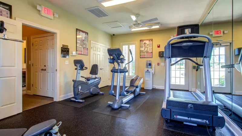 Fully equipped fitness center with cardio machines, stationary bikes, and strength training equipment at Lauren Ridge Apartment Homes.