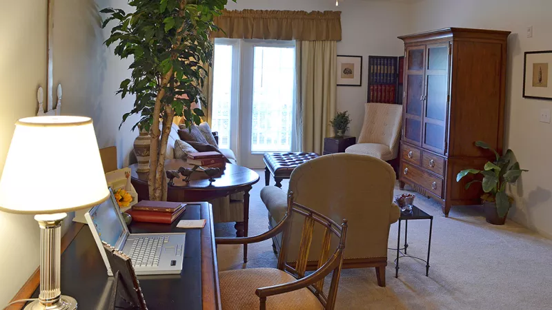 Comfortable living area with home office setup, natural light, and classic furnishings at Market Street Station