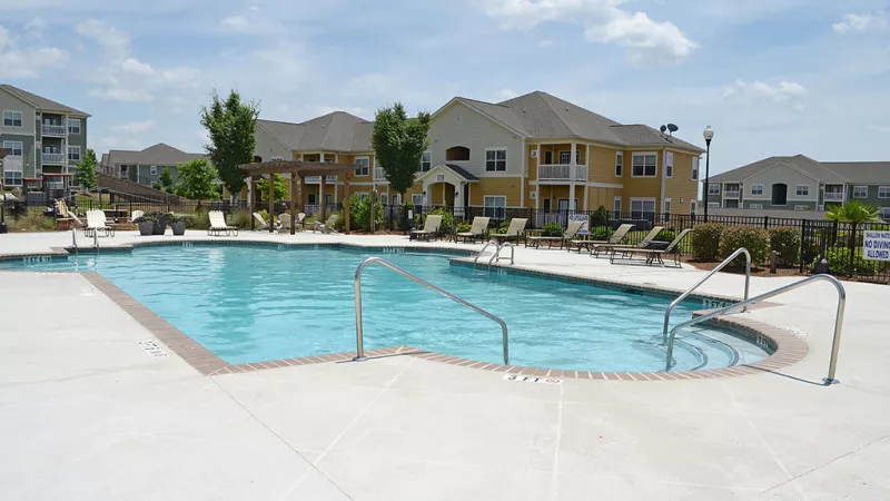 Large outdoor swimming pool with handrails and ample lounge seating at Market Street Station