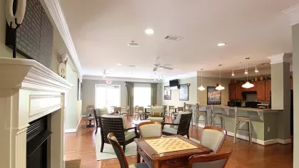 Multi-use resident clubhouse at Reed Creek Apartments with game tables, a community kitchen, and relaxed social space.