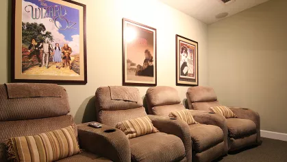 Private theater room at Reed Creek Apartments with plush recliners and classic movie posters, perfect for resident entertainment.