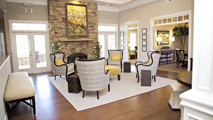 Elegant clubhouse interior at The Heights at Lake Murray featuring cozy seating, framed art, and wood-style flooring