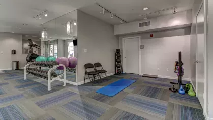 Well-equipped fitness studio at The Saulet with yoga mats, kettlebells, and exercise balls for a full-body workout.