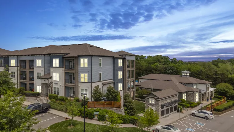 Twilight aerial of Avery at Turkey Creek highlighting apartment homes, clubhouse, and parking areas.
