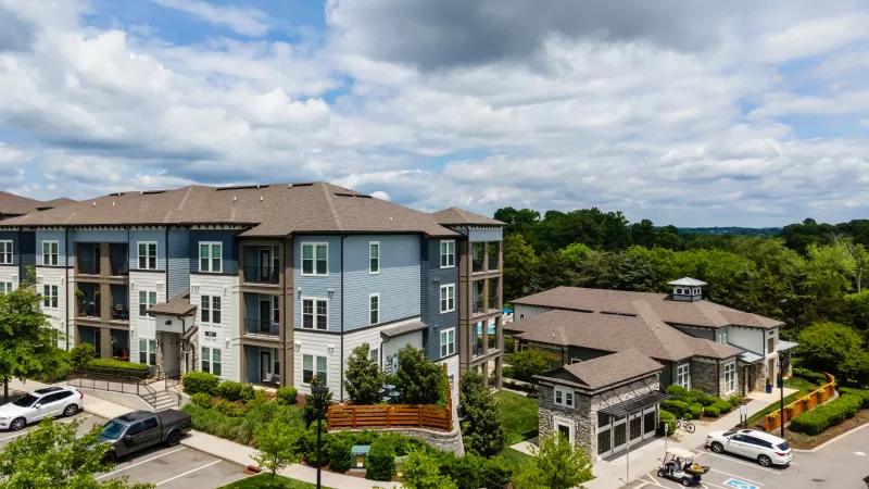Avery at Turkey Creek modern apartment buildings with private balconies and tree-lined parking lot