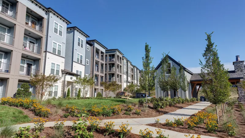 Contemporary apartment exteriors with balconies and landscaped walkways at Avery at Turkey Creek