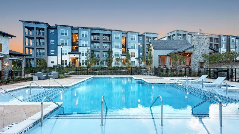 Resort-style swimming pool with lounge chairs and sundeck at Avery Turkey Creek Apartments.