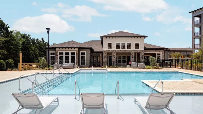 Clubhouse and pool area at Avery Turkey Creek with in-water loungers, sundeck, and outdoor seating.