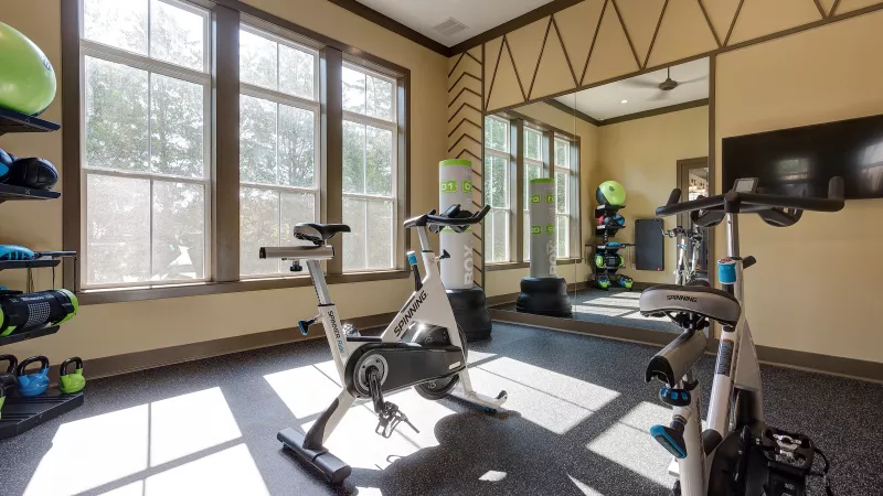 Spin studio with exercise bikes, training equipment, and large windows at Tapestry Turkey Creek fitness center.