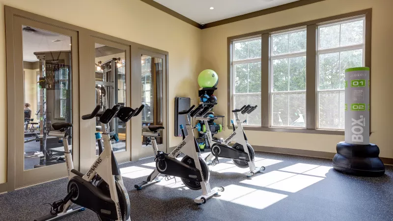 Fitness room with spin bikes, boxing equipment, and yoga accessories at Tapestry Turkey Creek.