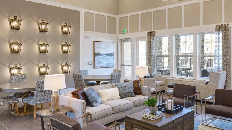 Elegant resident lounge with lantern-style wall lighting, comfortable seating, and natural light at Avery Turkey Creek.