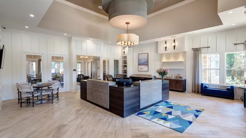Leasing office at Avery Turkey Creek Apartments with modern reception desk, chandelier, and welcoming décor.