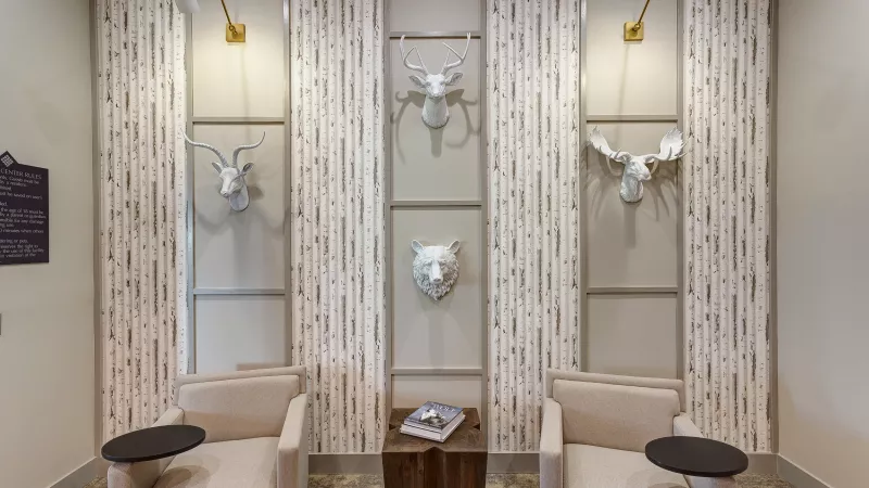 Lounge seating with sculpted wall art in the business center at Avery Turkey Creek Apartments.