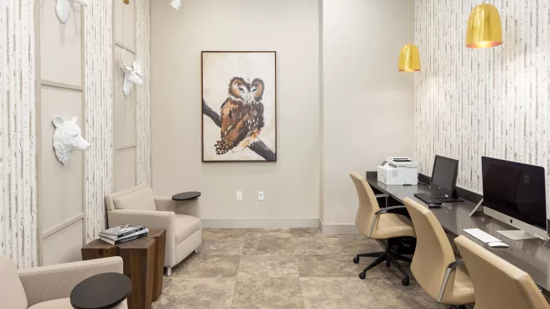 Business center workspace with computers, printer, and contemporary décor at Avery Turkey Creek.