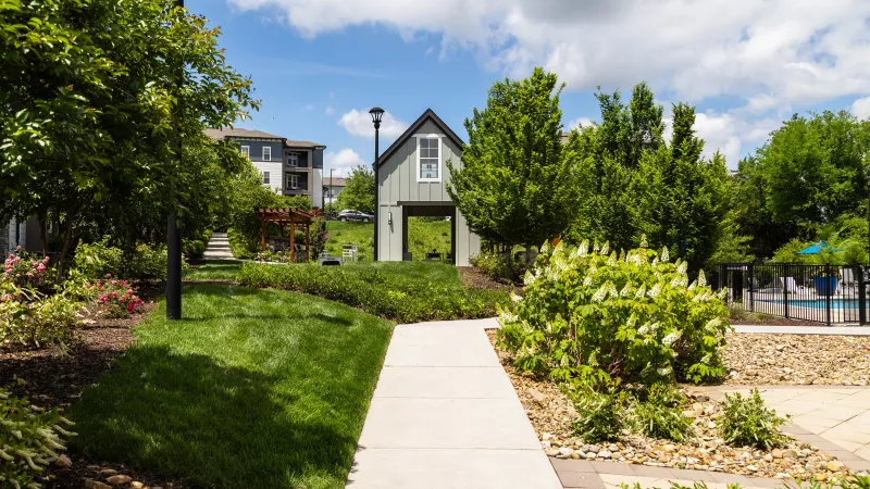 Landscaped community walkway with greenery and pavilion view at Avery at Turkey Creek Apartments.