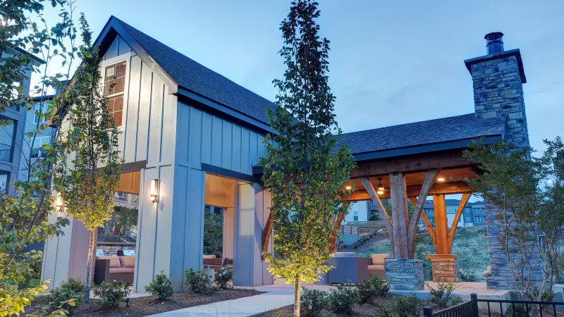 Pavilion at Avery at Turkey Creek Apartments with vaulted ceiling, stone fireplace, and evening lighting.