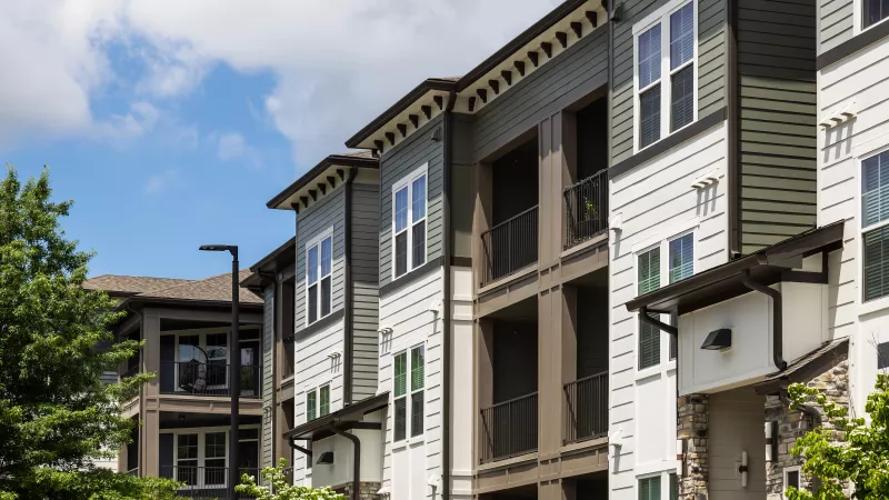 Apartment exterior at Avery at Turkey Creek featuring balconies, large windows, and modern siding.