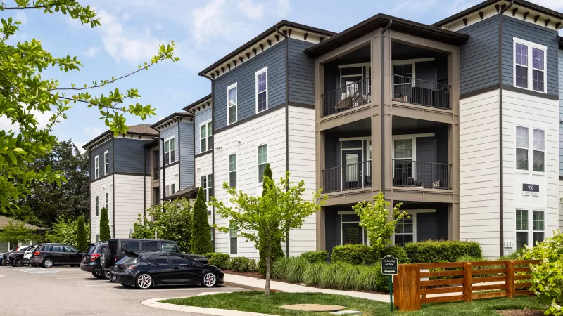 Apartment building exterior with balconies, modern siding, and parking area at Avery at Turkey Creek.