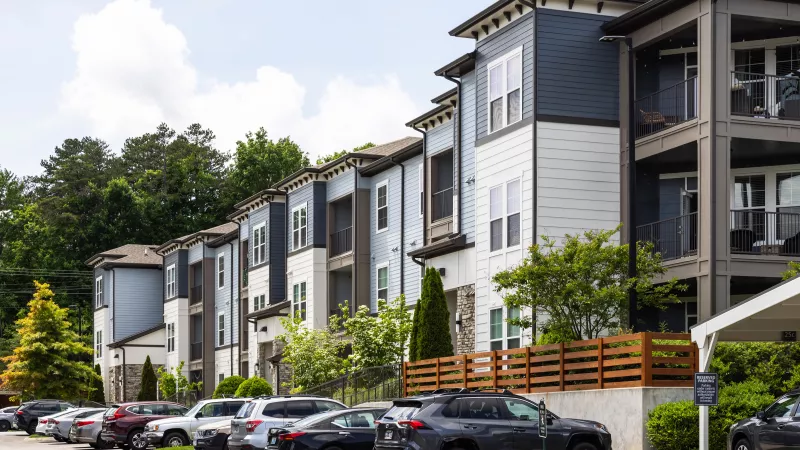Exterior view of Avery at Turkey Creek apartments with modern architecture, private balconies, and resident parking.