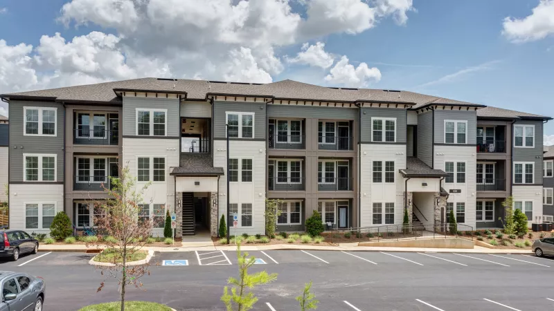 Wide view of Avery at Turkey Creek apartment building with multiple balconies and open parking lot.