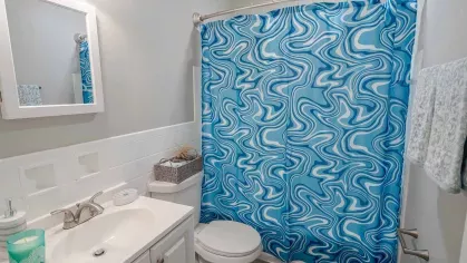 Contemporary bathroom at Montgomery Plaza Apartments featuring clean finishes, vanity lighting, and tub-shower combo.