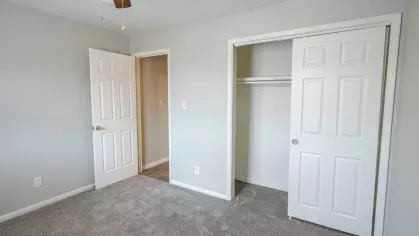 Cozy bedroom at Montgomery Plaza Apartments with plush carpeting, large closet, and natural light.
