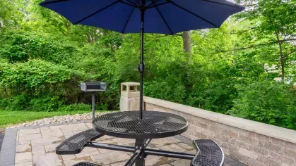 Community outdoor seating space with multiple black tables and greenery at Montgomery Plaza Apartments